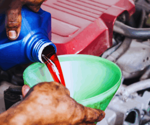 mecanic pouring transmission fluid into semi truck